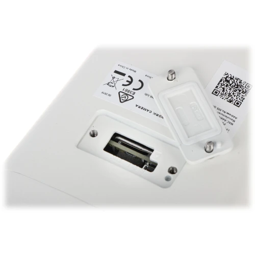 Zdjęcie przedstawia gniazdo na kartę pamięci umieszczone w białej obudowie urządzenia, z otwartą pokrywą zabezpieczającą. Obok gniazda znajdują się naklejki z kodem QR oraz oznaczeniami certyfikacyjnymi.