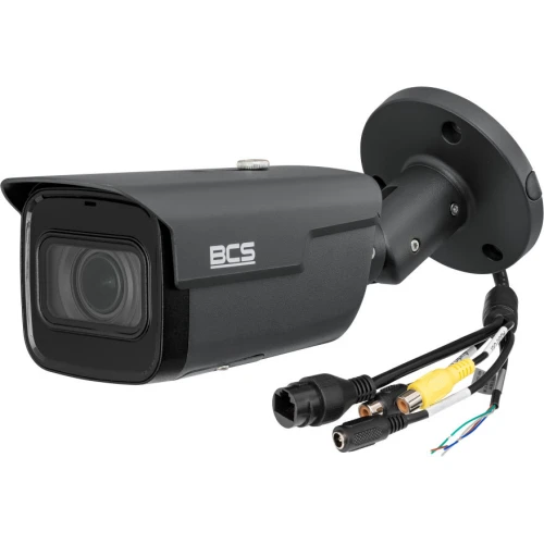 Na zdjęciu znajduje się czarna kamera IP marki BCS z widocznymi kablami połączeniowymi. Kamera ma cylindryczny kształt i jest przeznaczona do montażu zewnętrznego.