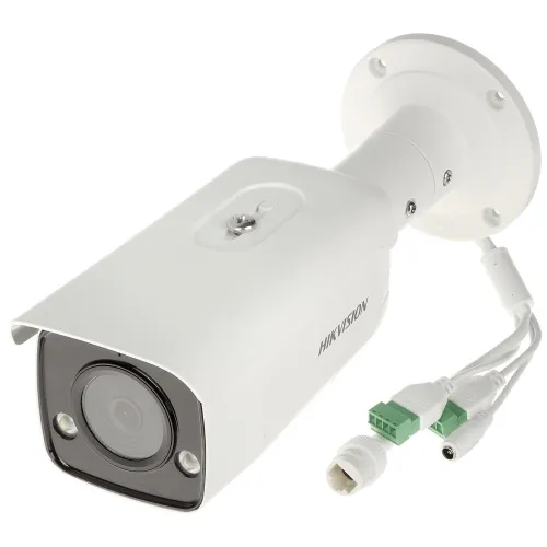 Biała kamera IP Hikvision z obiektywem i złączami kablowymi widoczna na białym tle. Kamera ma cylindryczny kształt i jest przeznaczona do montażu na ścianie lub suficie.