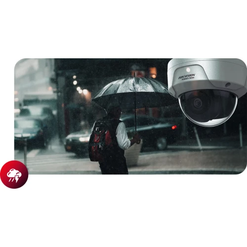 Na zdjęciu widać osobę z plecakiem idącą w deszczu pod parasolem na tle miejskiej ulicy. W prawym górnym rogu znajduje się zbliżenie na kamerę IP marki Hikvision.