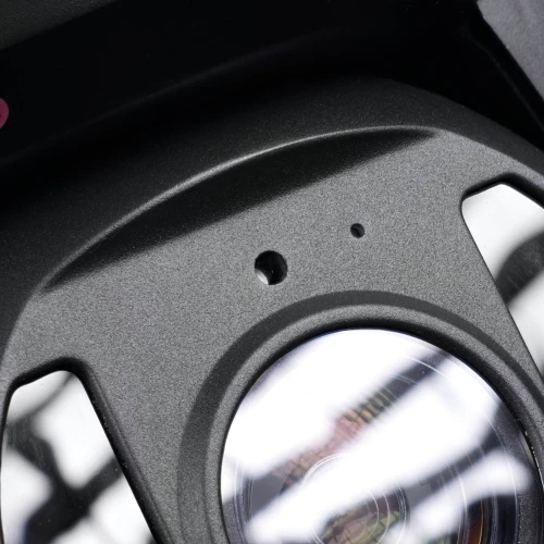 Zbliżenie na obiektyw kamery obrotowej IP z widocznymi refleksami świetlnymi na powierzchni soczewki. Obudowa kamery jest w kolorze czarnym z dwoma małymi otworami nad obiektywem.