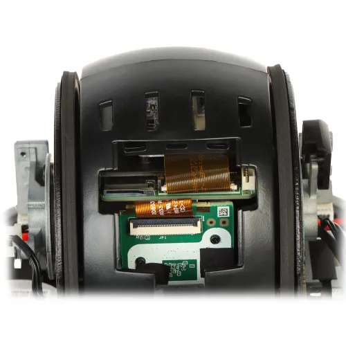 Zdjęcie przedstawia wnętrze kamery po zdjęciu klosza, ukazując szczegóły elektroniki i okablowania. Widoczne są elementy obwodów drukowanych oraz złącza taśmowe.