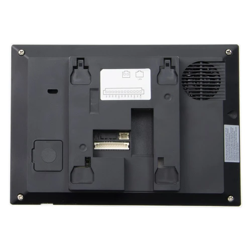 Zdjęcie przedstawia tylną część czarnego monitora wideodomofonowego z widocznymi złączami i otworami montażowymi. W prawym górnym rogu znajduje się kratka wentylacyjna, a na środku etykieta z diagramem połączeń.