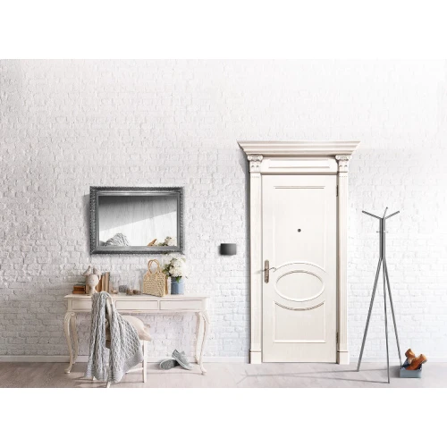 Na zdjęciu znajduje się elegancki sterownik gestów Fibaro Swipe zamontowany na ścianie obok drzwi, w stylowo urządzonym wnętrzu. Produkt jest dyskretnie wkomponowany w przestrzeń, podkreślając nowoczesny design pomieszczenia.