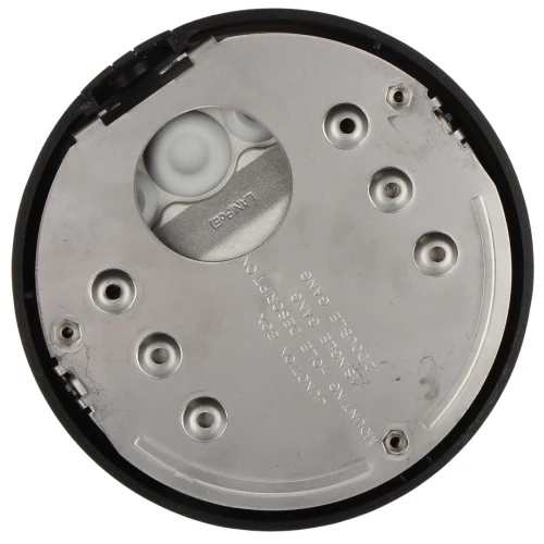 Zdjęcie przedstawia widok od spodu okrągłej obudowy montażowej z metalową płytą i kilkoma otworami na śruby. Wewnątrz znajduje się biała, plastikowa część z widocznymi napisami.