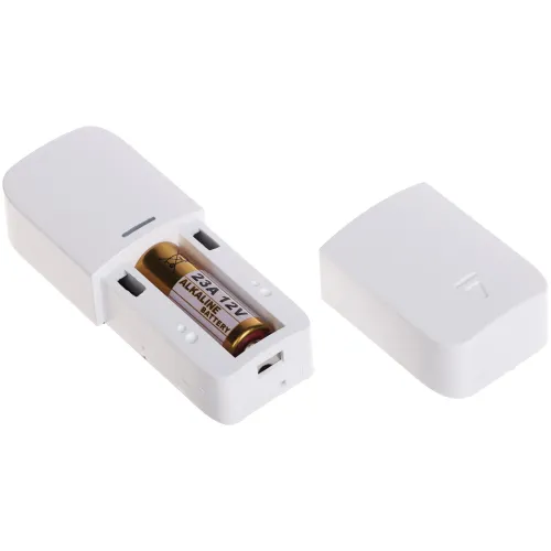 Na zdjęciu znajduje się otwarta biała obudowa urządzenia elektronicznego, w której widoczna jest bateria alkaliczna 12V typu 23A. Obok leży zdjęta pokrywa obudowy.