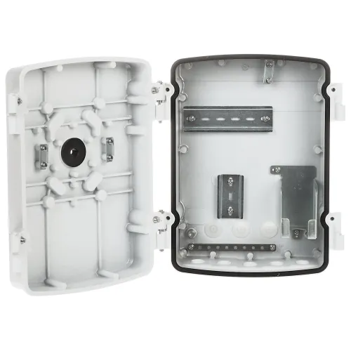 Zdjęcie przedstawia otwartą, pustą obudowę elektryczną z tworzywa sztucznego, z widocznymi miejscami na montaż komponentów. Wnętrze obudowy jest wyposażone w metalowe szyny i uchwyty do mocowania urządzeń elektrycznych.