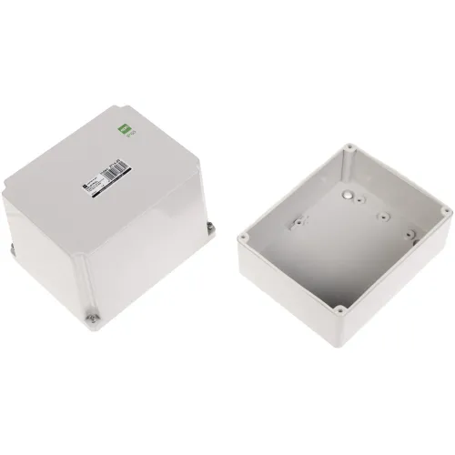 Na zdjęciu znajdują się dwie szare, prostokątne obudowy elektryczne z tworzywa sztucznego, jedna z pokrywą, a druga otwarta, ukazująca wnętrze. Na pokrywie widoczna jest etykieta z kodem kreskowym i informacjami o produkcie.