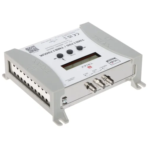Zdjęcie przedstawia urządzenie elektroniczne marki Triax z wyświetlaczem i trzema złączami koncentrycznymi na przednim panelu. Obudowa jest w kolorze szarym, z widocznymi oznaczeniami i przyciskami na górnej powierzchni.
