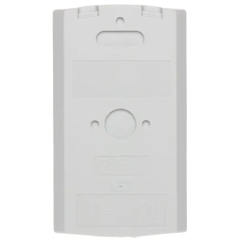 Prostokątna, biała obudowa z tworzywa sztucznego z otworem na środku i kilkoma mniejszymi otworami oraz wytłoczonymi symbolami. Górna część obudowy posiada otwór do zawieszenia.