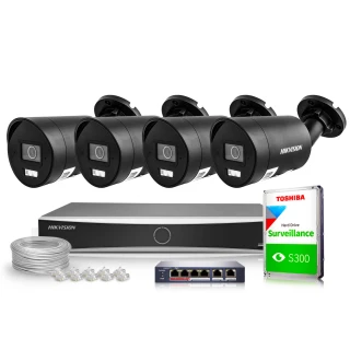Zestaw do monitoringu składający się z czterech czarnych kamer Hikvision, rejestratora, dysku twardego Toshiba oraz akcesoriów montażowych. Na zdjęciu widoczne są również kable i przełącznik sieciowy.